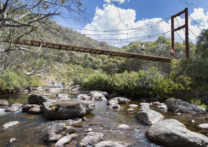 Mountain bikers travelling over a footbridge on the Thredbo Valley Track, Kosciuszko National Park